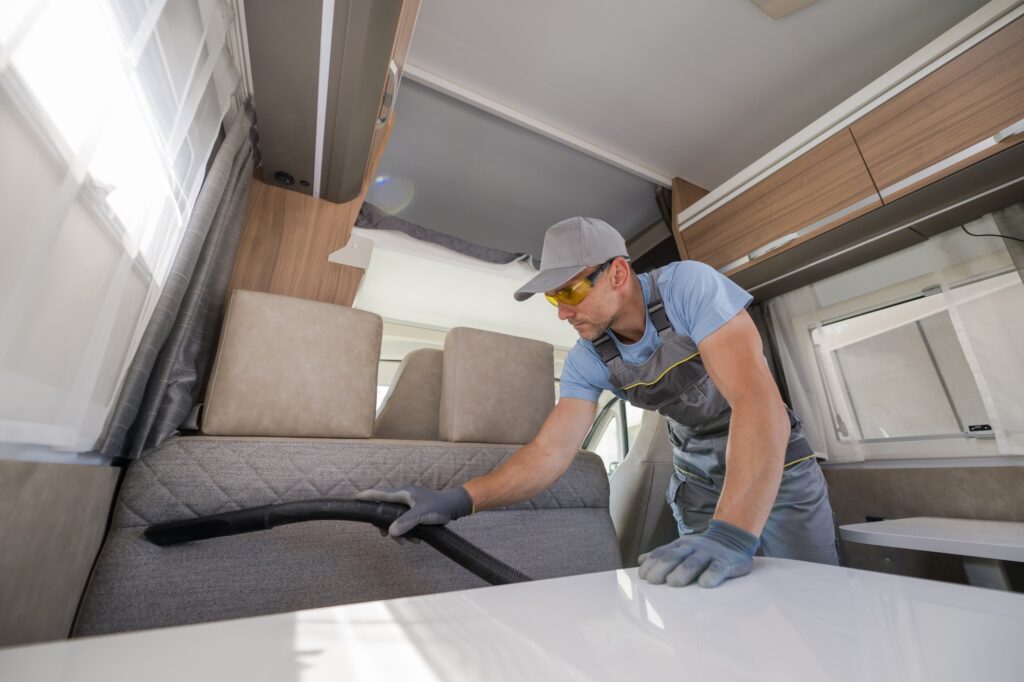 Cleaning Services Worker Vacuuming the RV Furniture